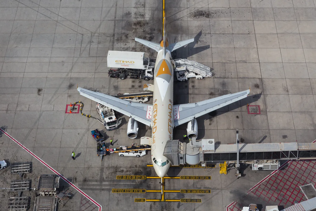 Top-down view of an Etihad aircraft at an apron stand